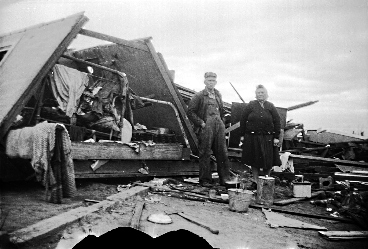 Man and Woman Inspect Destroyed Home